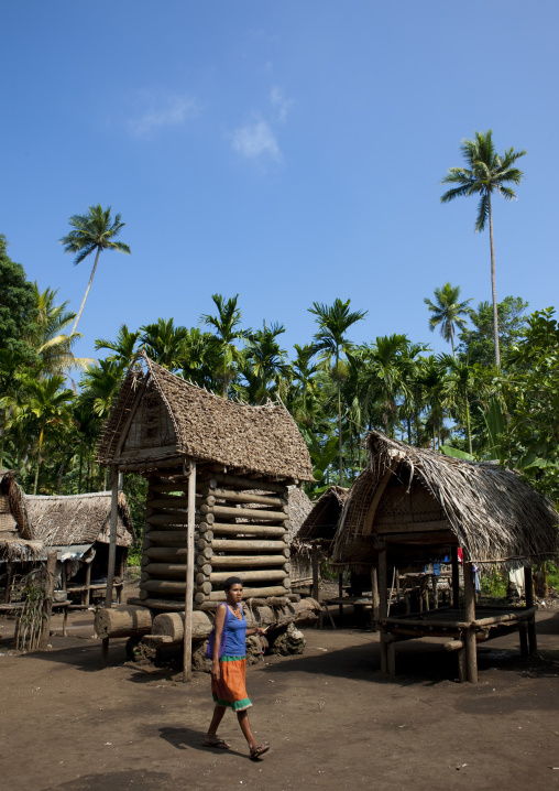 Woman with a malagan in front of a yam house, Milne Bay Province, Trobriand Island, Papua New Guinea