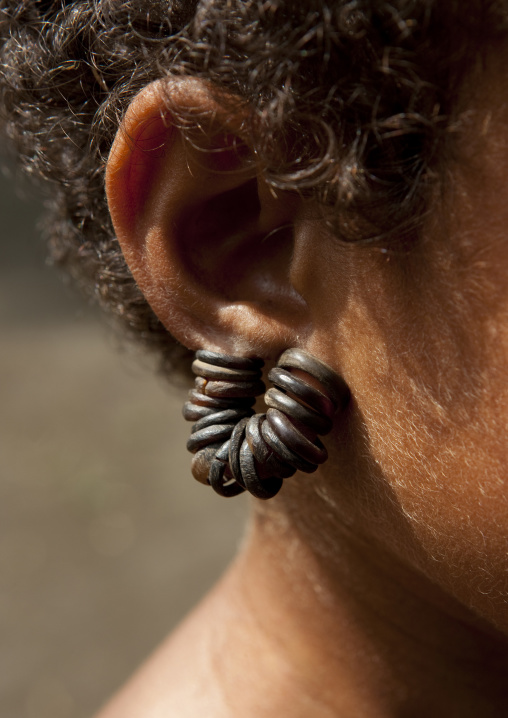 Little girl wearing earrings made with turtle shell, Milne Bay Province, Trobriand Island, Papua New Guinea