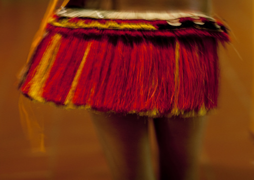 Woman wearing a traditional red skirt made with pandanus and banana leaves, Milne Bay Province, Trobriand Island, Papua New Guinea