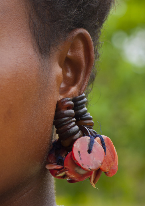 Little girl wearing earrings made with turtle shell, Milne Bay Province, Trobriand Island, Papua New Guinea