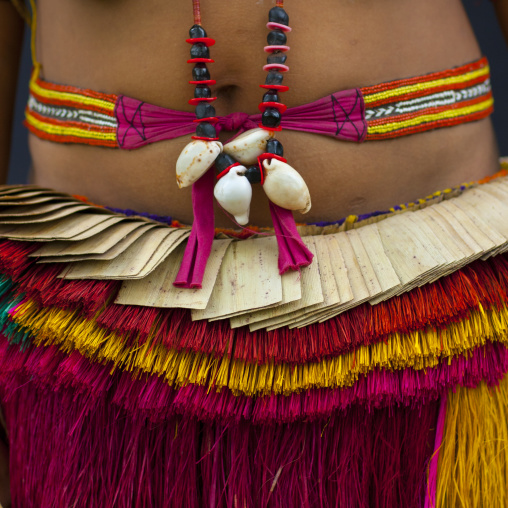 Woman wearing a traditional red skirt made with pandanus and banana leaves, Milne Bay Province, Trobriand Island, Papua New Guinea