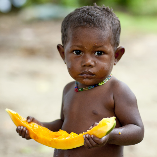 Boy eating a papaya, Autonomous Region of Bougainville, Bougainville, Papua New Guinea