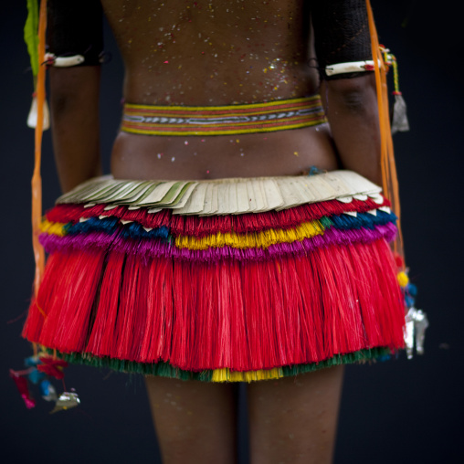 Woman wearing a traditional red skirt made with pandanus and banana leaves, Milne Bay Province, Trobriand Island, Papua New Guinea