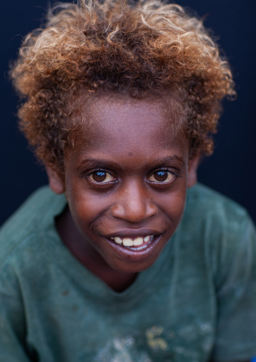 Portrait of a smiling boy with blonde hair, New Ireland Province, Langania, Papua New Guinea