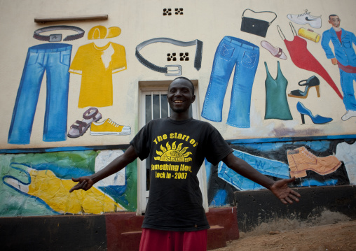 Rwandan man in front of a tailor shop mural, Kigali Province, Kigali, Rwanda