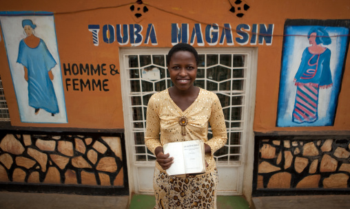 Rwandan woman in front of a tailor shop mural, Kigali Province, Kigali, Rwanda