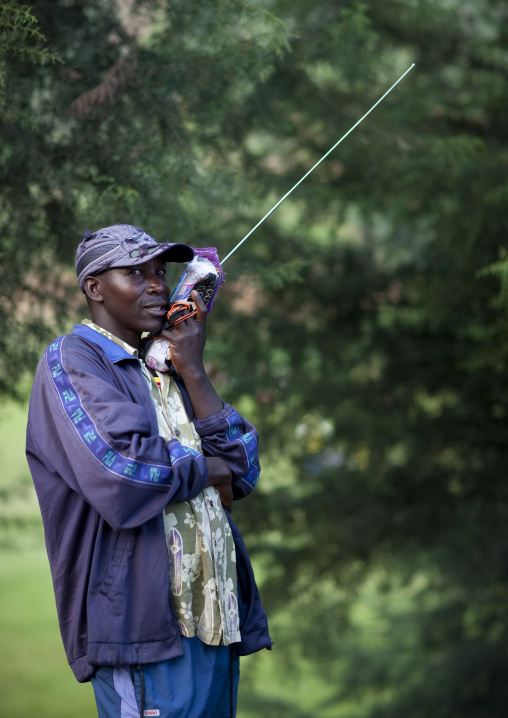 Rwandan man listening tov the radio in the countryside, Northwest Province, Rehengeri, Rwanda