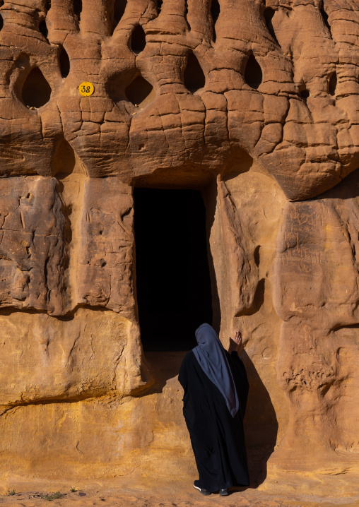 Saudi tourist in front of a tomb in al-Hijr archaeological site in Madain Saleh, Al Madinah Province, Alula, Saudi Arabia