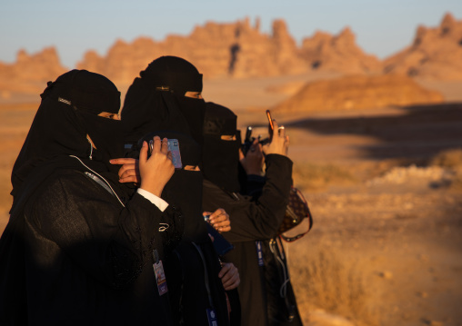 Saudi women in black niqabs taking pictures, Al Madinah Province, Alula, Saudi Arabia