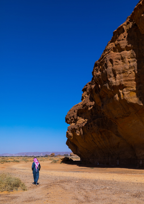 Sausi man walking in the middle of the mountains of wadi al gura, Al Madinah Province, Alula, Saudi Arabia