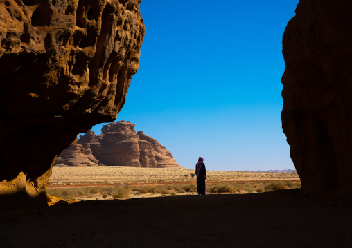 Sausi man walking in the middle of the mountains of wadi al gura, Al Madinah Province, Alula, Saudi Arabia