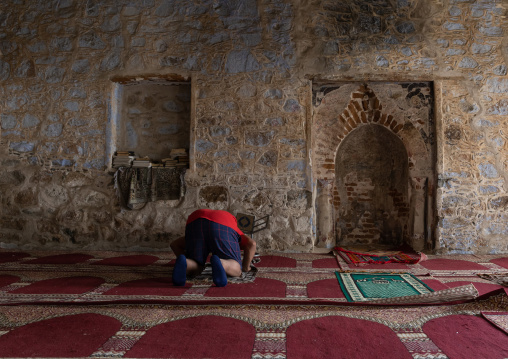 Saudi man praying in the ottoman qantara mosque also known as al-Madhoun mosque, Mecca province, Taïf, Saudi Arabia