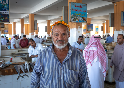 Saudi man with a flower garland i the fish market, Jizan Province, Jizan, Saudi Arabia