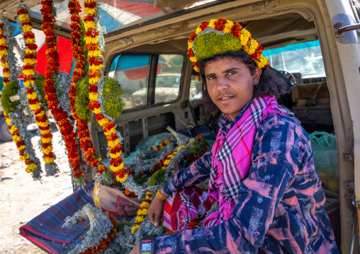 A flower vendor preparing floral garlands and crowns on a market in the back of his car, Jizan Province, Addayer, Saudi Arabia