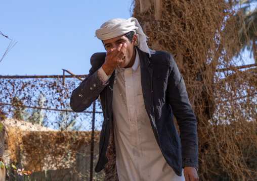 Thirsty saudi man drinking water in a farm well, Najran Province, Najran, Saudi Arabia