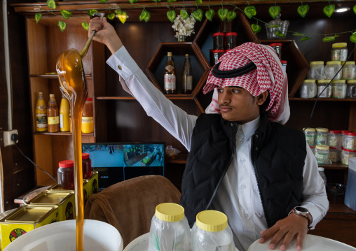 Saudi man selling honey in a shop, Asir province, Abha, Saudi Arabia