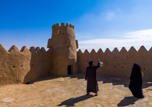 Saudi tourists taking pictures in the court of qasr zaba al, Al-Jawf Province, Sakaka, Saudi Arabia