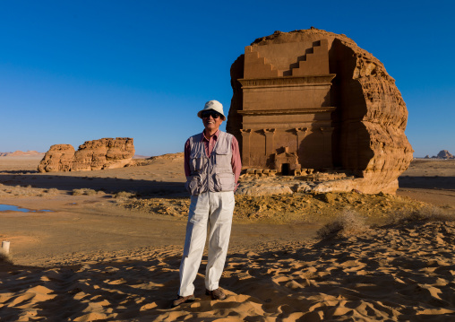 Japanese tourist in front of qsar farid nabataean tomb in madain saleh archaeologic site, Al Madinah Province, Al-Ula, Saudi Arabia