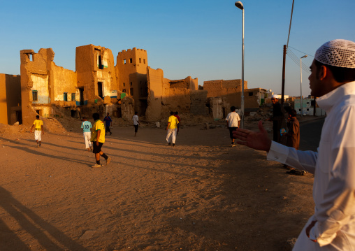 Saudi men playing football in the middle of old houses, Najran Province, Najran, Saudi Arabia