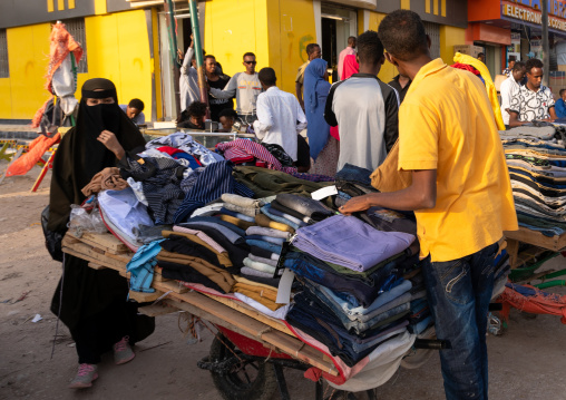 Somali man selling clothes to a woman wearing a burqa, Woqooyi Galbeed region, Hargeisa, Somaliland