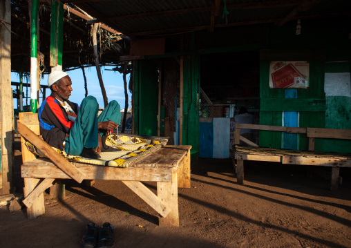 Somali man resting on a bed in a bar, Awdal region, Zeila, Somaliland