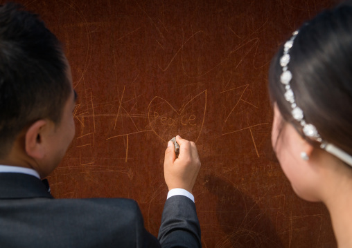 North korean defector joseph park with his south korean fiancee juyeon writing a peace message on the north and south korea border, Sudogwon, Paju, South korea