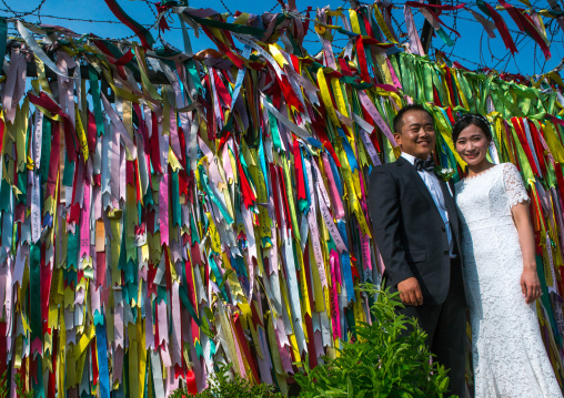 North korean defector joseph park with his south korean fiancee juyeon in front of messages of peace written on ribbons left on dmz, Sudogwon, Paju, South korea