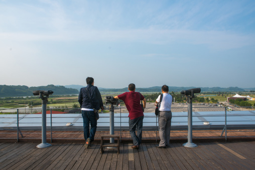 South korean men looking over the north and south korea border at the jsa, Sudogwon, Paju, South korea