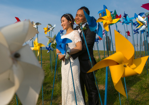 North korean defector joseph park with his south korean fiancee called juyeon in the middle of windmills in imjingak park, Sudogwon, Paju, South korea