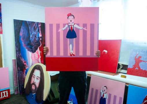 Sun mu artist hiding behind a painting of his happy children serie, National capital area, Seoul, South korea