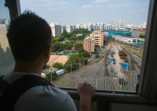 North korean defector joseph park in his former apartment in yangcheong looking at the rail maintenance workshop, National capital area, Seoul, South korea