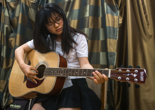 North korean teen defector in yeo-mung alternative school playing guitar, National capital area, Seoul, South korea