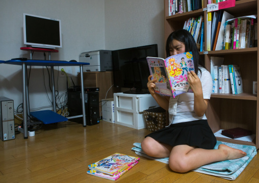 North korean teen defector reading a korean manga book, National capital area, Seoul, South korea