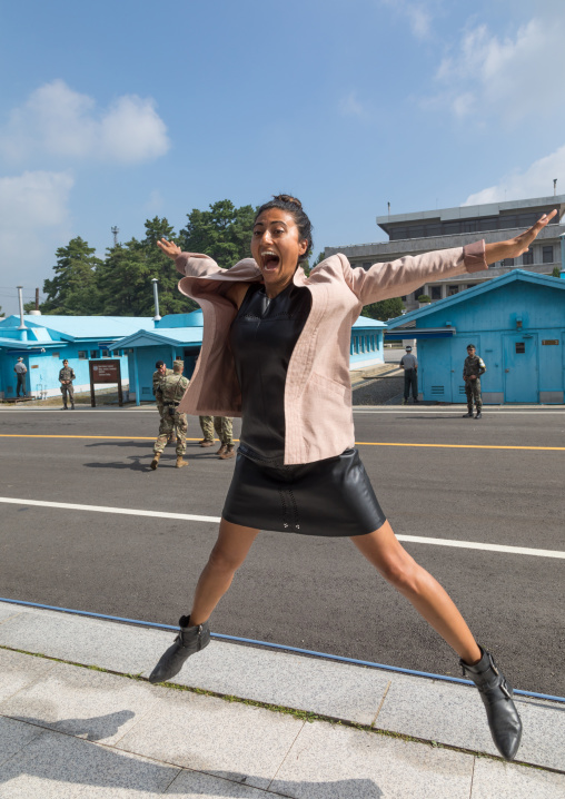 Tourist jumping for a photo souvenir in the joint security area on the border between the two Korea, North Hwanghae Province, Panmunjom, South Korea