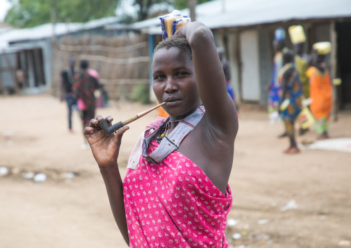 Toposa tribe woman smoking pipe in the street, Namorunyang State, Kapoeta, South Sudan