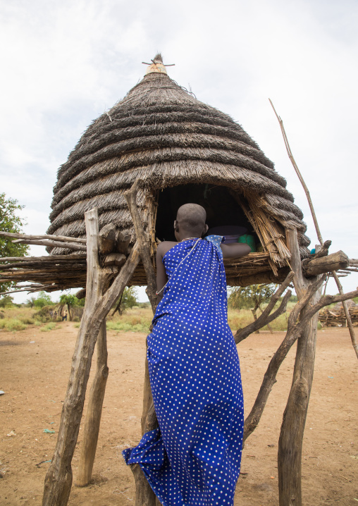 Toposa tribe girl climbing in a granary in a village, Namorunyang State, Kapoeta, South Sudan