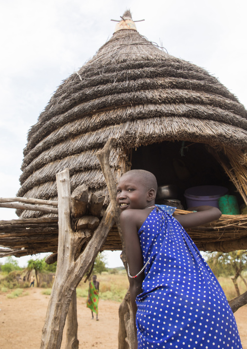 Toposa tribe girl climbing in a granary in a village, Namorunyang State, Kapoeta, South Sudan