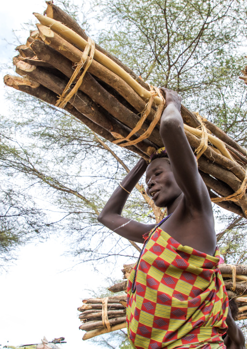 Toposa tribe woman carrying wood branches on her head, Namorunyang State, Kapoeta, South Sudan