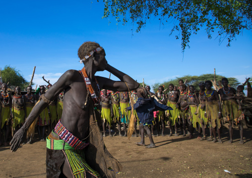 Toposa tribe woman in traditional clothing dancing during a ceremony, Namorunyang State, Kapoeta, South Sudan