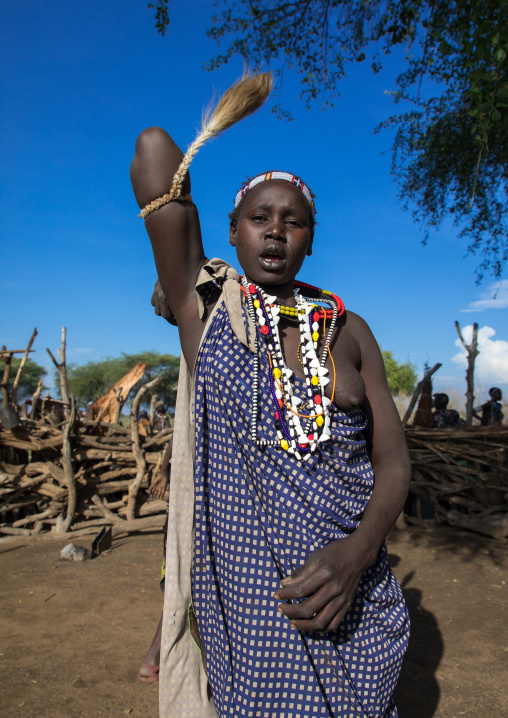 Toposa tribe woman in traditional clothing dancing during a ceremony, Namorunyang State, Kapoeta, South Sudan