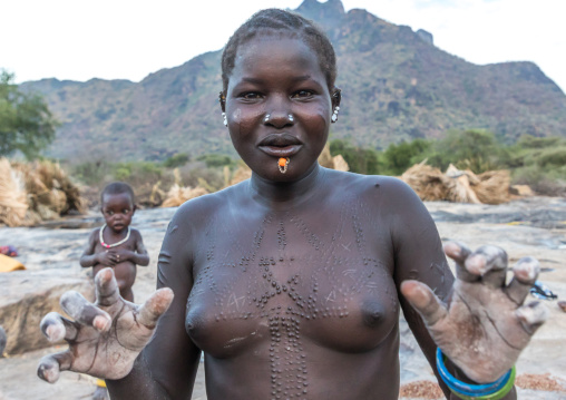 Larim tribe women grinding Sorghum grains, Boya Mountains, Imatong, South Sudan