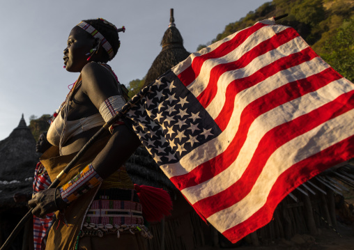 Larim tribe woman with an american flag during a wedding celebration, Boya Mountains, Imatong, South Sudan