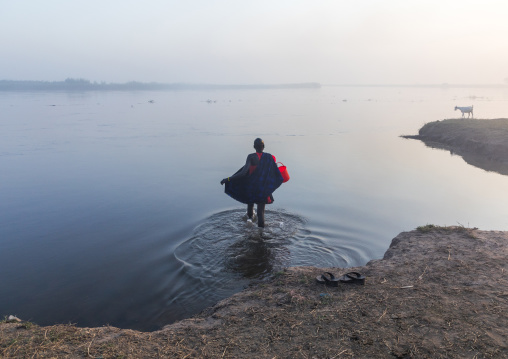 Mundari tribe woman collecting water in the river Nile, Central Equatoria, Terekeka, South Sudan