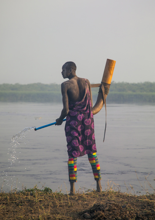 Mundari tribe man cleaning a cow horn, Central Equatoria, Terekeka, South Sudan