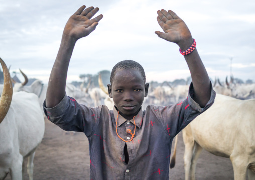 A Mundari tribe boy mimics the position of horns of his favourite cow, Central Equatoria, Terekeka, South Sudan