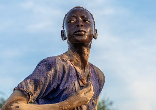 Mundari tribe man putting ash on his body after showering with cow urine, Central Equatoria, Terekeka, South Sudan