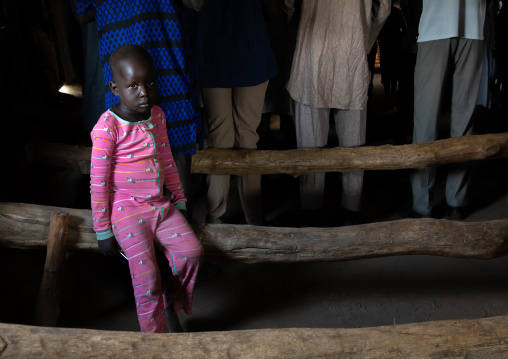 Mundari tribe girl sit on a wooden bench during a sunday mass in a church, Central Equatoria, Terekeka, South Sudan