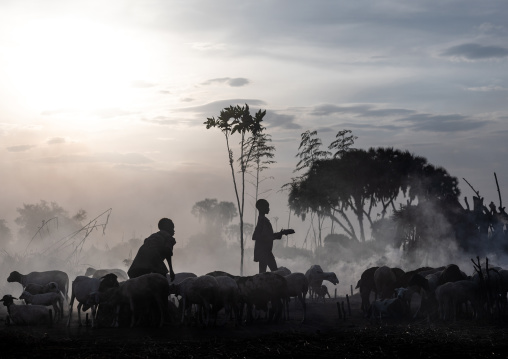 Mundari tribe boys taking care of the bonfires made with dried cow dungs to repel flies and mosquitoes, Central Equatoria, Terekeka, South Sudan