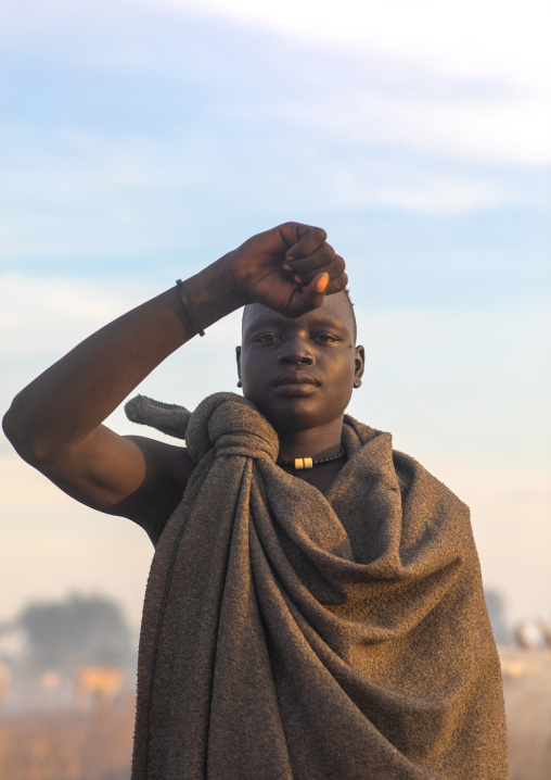 Portrait of a Mundari tribe man mimics the position of horns of his favourite cow, Central Equatoria, Terekeka, South Sudan