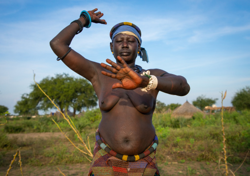 A Mundari tribe woman mimics the position of horns of his favourite cow, Central Equatoria, Terekeka, South Sudan